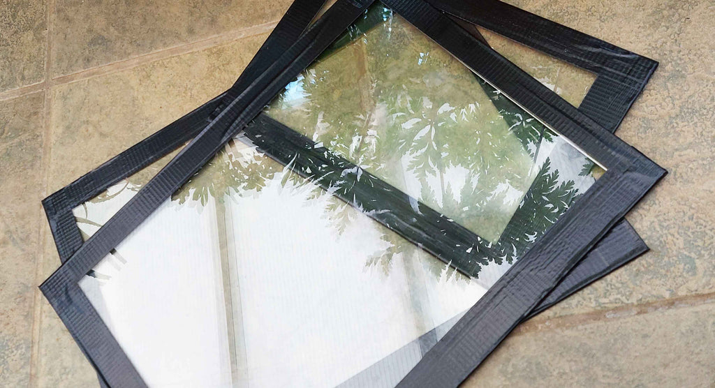 Three sheets of glass with tape around the edges